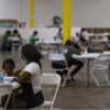 Two Haitian asylum seekers enjoy a meal at the NACC shelter. Photo by Leonardo March