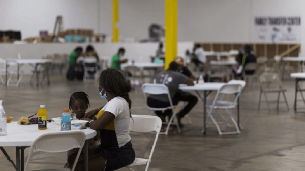 Two Haitian asylum seekers enjoy a meal at the NACC shelter. Photo by Leonardo March
