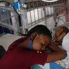 A woman sleeping beside a child in a pediatric center