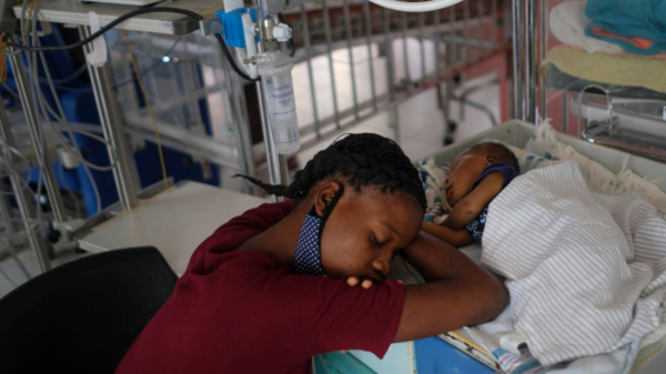 A woman sleeping beside a child in a pediatric center