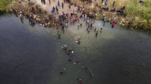 Immigrants, many from Haiti, are seen wading between the U.S. and Mexico on the Rio Grande on Sept. 21, 2021