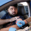 Sitting in his car, social worker Jonathan De La Rosa