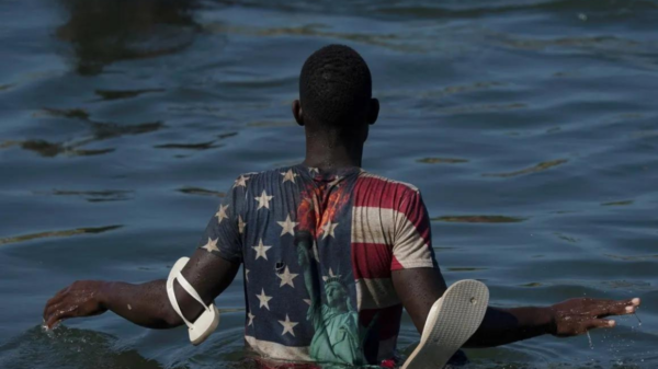 A Migrant wades across thr Rio Grand