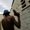 A gang member patrols in Cité Soleil slum