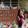 People visit a memorial outside of Robb Elementary