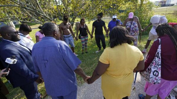 Residents pray near the store