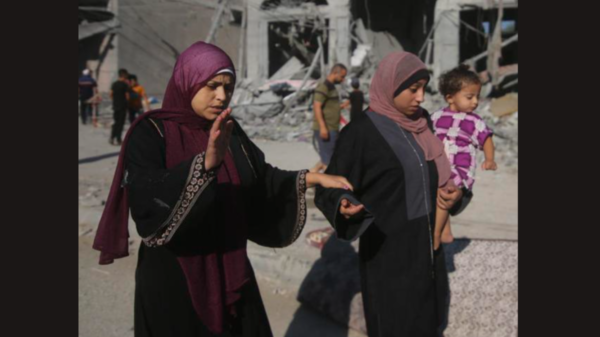 Palestinians leave their houses following Israeli airstrikes Thursday in Rafah refugee camp, southern Gaza Strip.