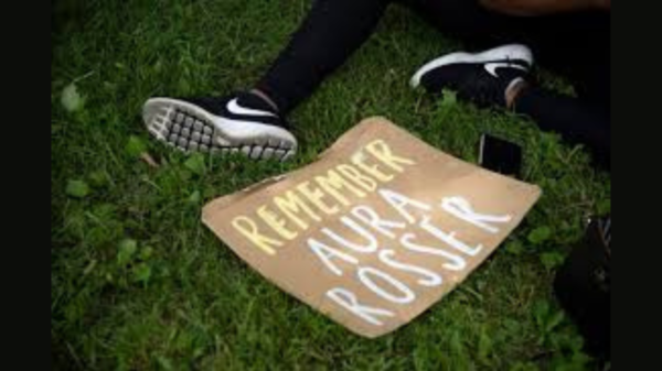A demonstrator lays a sign on the ground