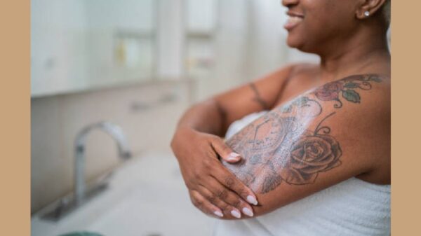 Woman applying body mosture in the bathroom at home