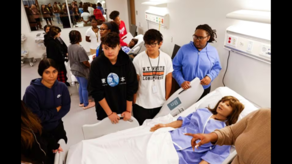 Students surround one of the several mannequins for health