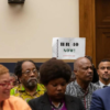 An attendee holds up a sign in support of HR 40