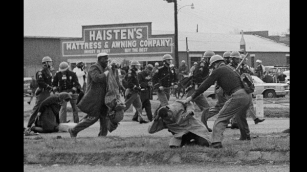 An Alabama state trooper swings a club