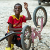 A boy playing with his bicycle