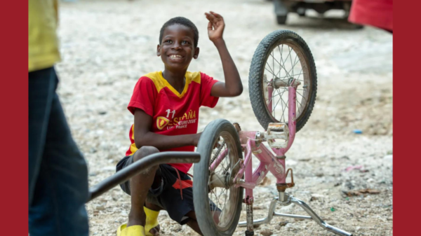 A boy playing with his bicycle